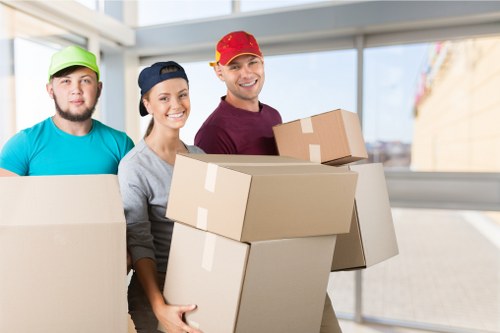 Apartment movers carrying boxes through a Croydon flat hallway